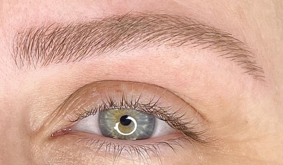 Ceja rubia después de un microblading pelo a pelo en un tono suave que no la oscurece, sobre un ojo gris azulado, en el estudio de Carla Tomás en Zaragoza