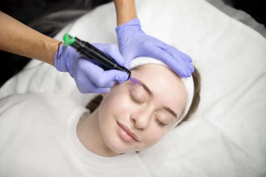 Clienta tumbada en camilla durante una sesión de micropigmentación de cejas, microblading natural Daroca